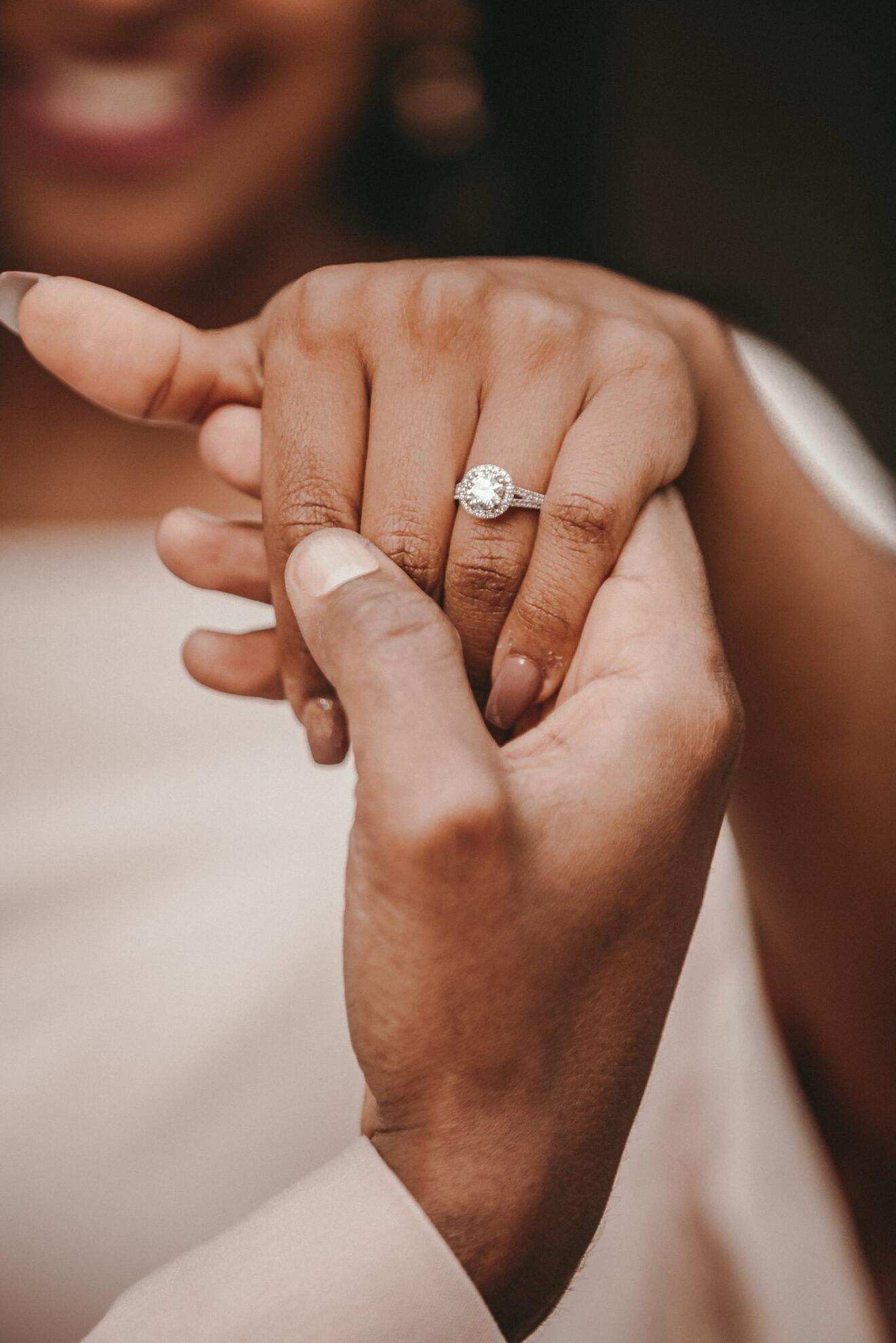 Hände eines Paares mit einem Verlobungsring, symbolisieren Liebe und Verlobung.